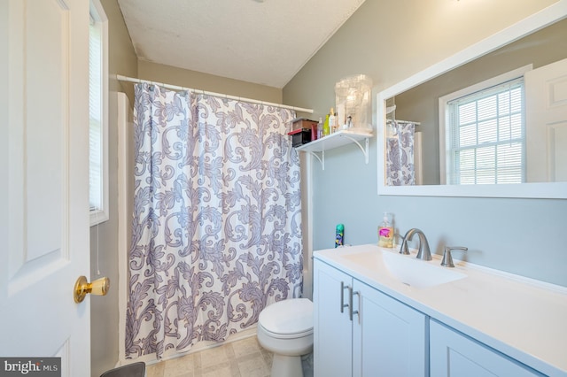 bathroom with vanity, toilet, and a textured ceiling