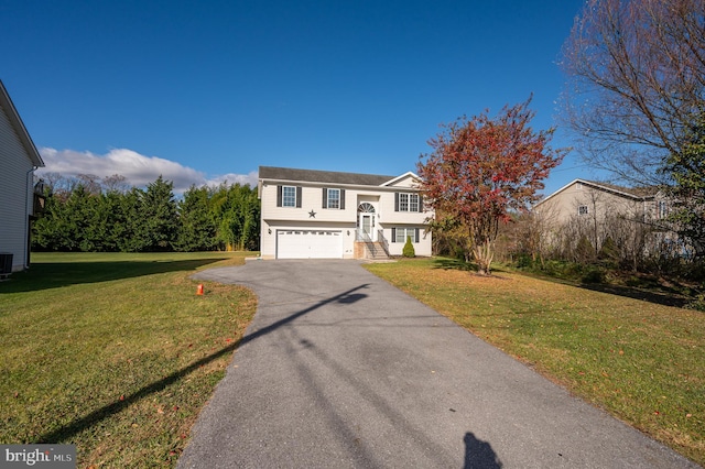 view of front of home featuring cooling unit, a garage, and a front lawn