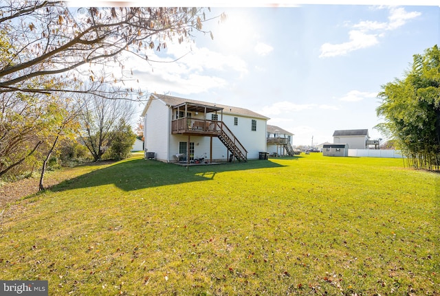 rear view of property featuring a lawn and a wooden deck