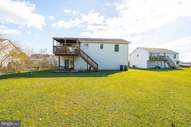 back of house featuring a lawn and a wooden deck