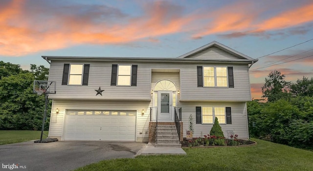 split foyer home with a yard and a garage