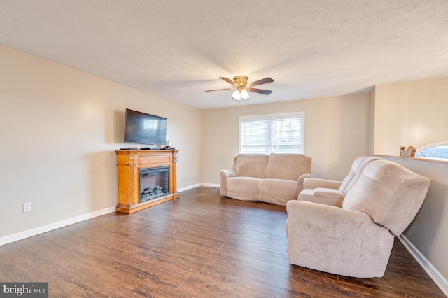 living room with a textured ceiling, dark hardwood / wood-style floors, and ceiling fan