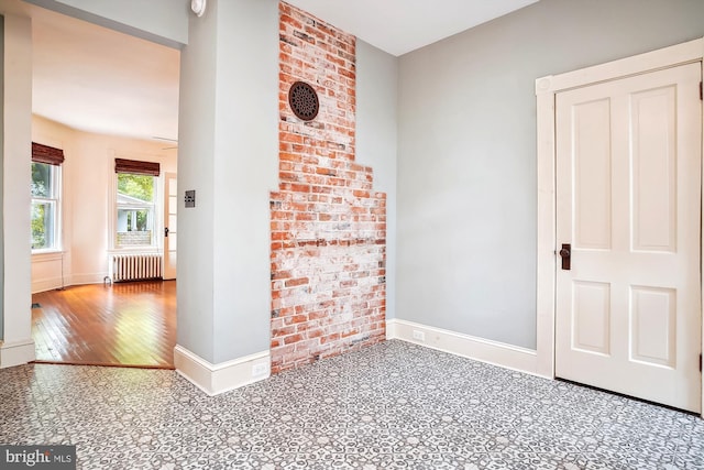 empty room featuring wood-type flooring and radiator