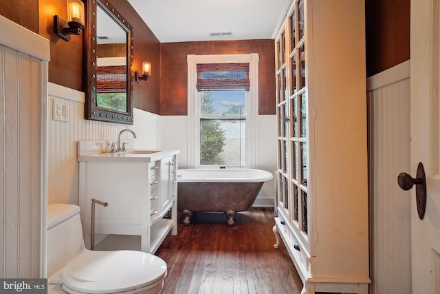 bathroom featuring hardwood / wood-style floors, vanity, a bathtub, and toilet