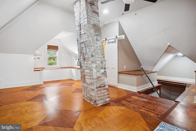 additional living space featuring a barn door, decorative columns, vaulted ceiling, and ceiling fan