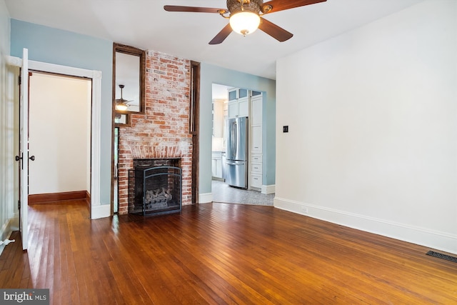 unfurnished living room with hardwood / wood-style floors, ceiling fan, and a fireplace