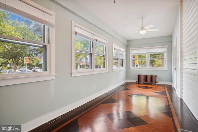 sunroom / solarium featuring ceiling fan and radiator