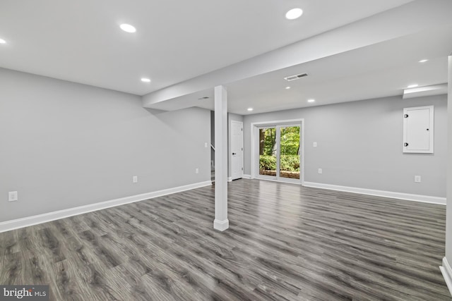 basement with dark wood-type flooring and electric panel