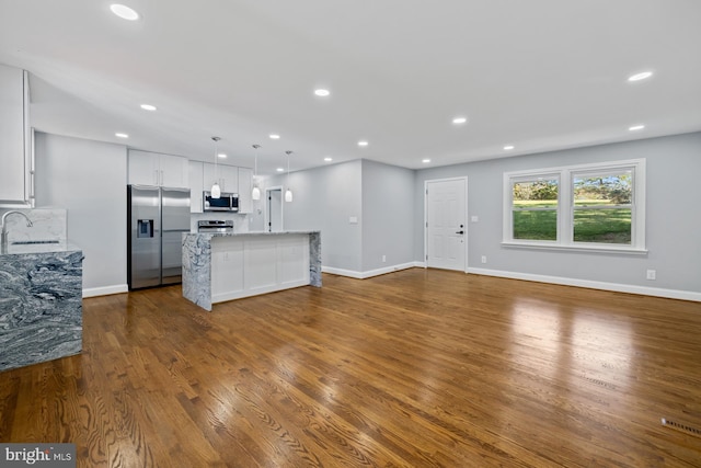 unfurnished living room featuring dark hardwood / wood-style floors and sink