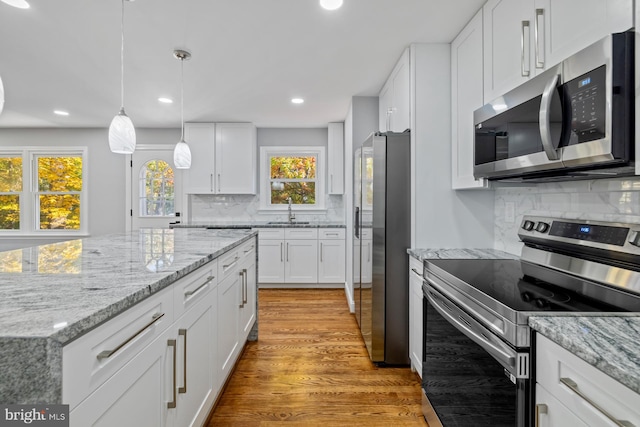 kitchen featuring light hardwood / wood-style flooring, white cabinets, and stainless steel appliances