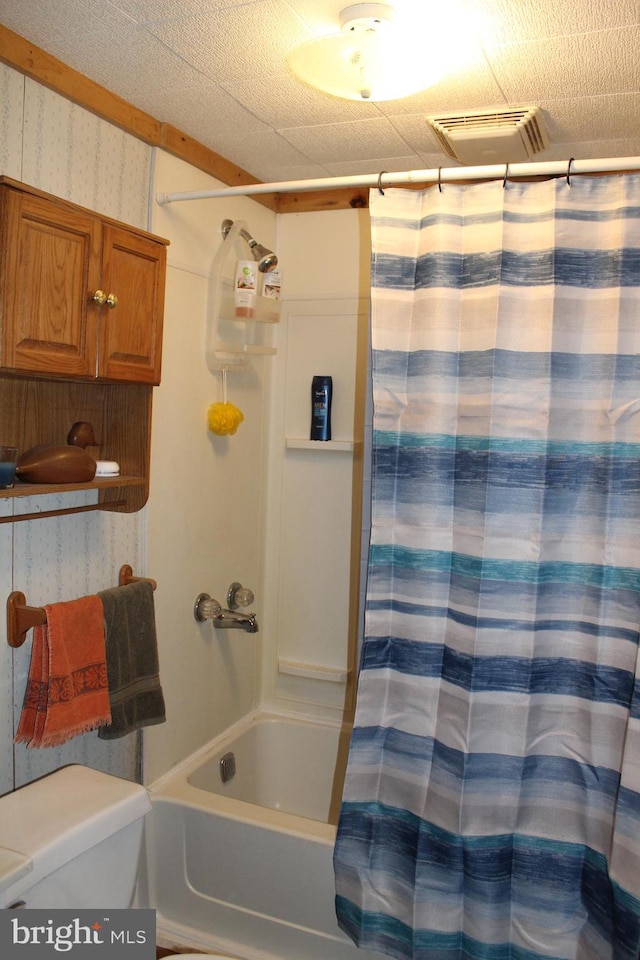 bathroom featuring toilet and shower / bathtub combination with curtain