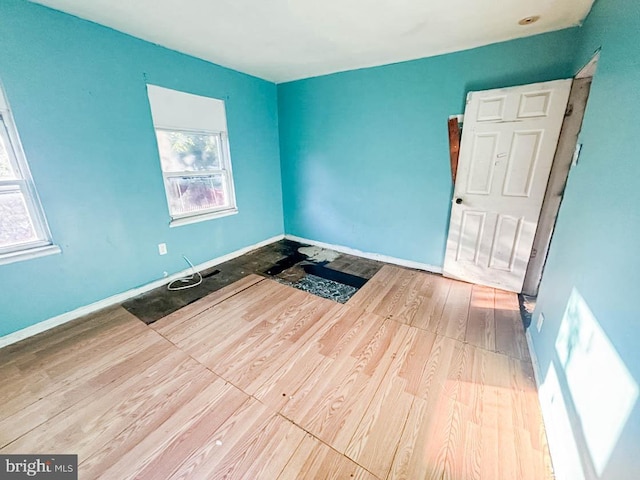 unfurnished room featuring baseboards and wood finished floors