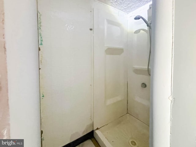 bathroom with a textured ceiling and walk in shower