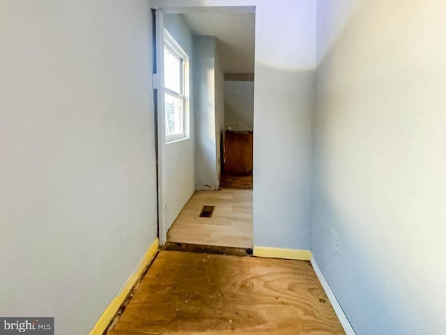 hallway featuring baseboards and wood finished floors