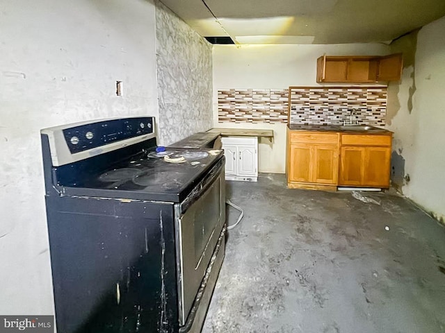 kitchen with concrete floors, stainless steel range with electric stovetop, a sink, brown cabinetry, and tasteful backsplash
