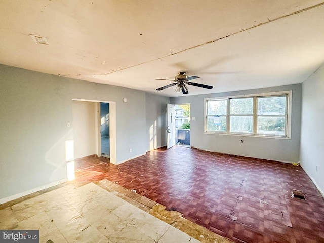 empty room featuring baseboards and ceiling fan