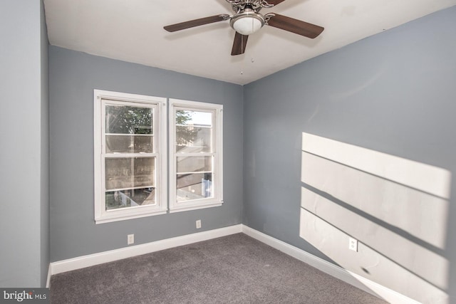 empty room featuring ceiling fan and dark carpet