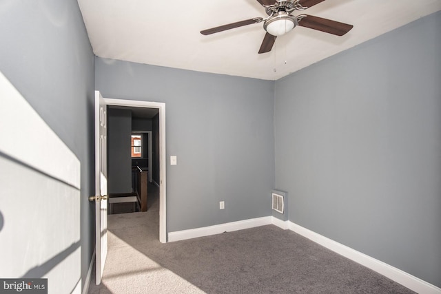 carpeted spare room with ceiling fan