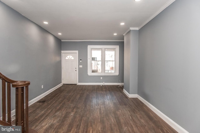 foyer entrance with ornamental molding and dark hardwood / wood-style floors