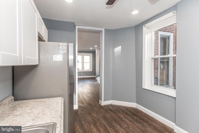 kitchen featuring white cabinetry, dark hardwood / wood-style flooring, ceiling fan, and stainless steel fridge