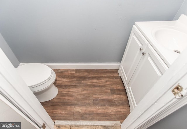 bathroom with hardwood / wood-style floors, vanity, and toilet