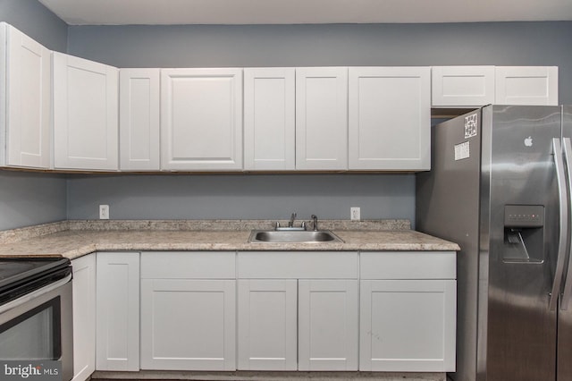 kitchen featuring white cabinets, stainless steel appliances, and sink