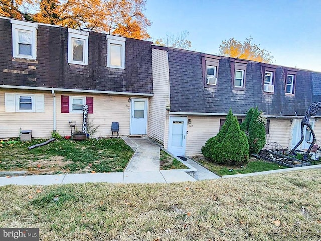 townhome / multi-family property featuring cooling unit and a front yard