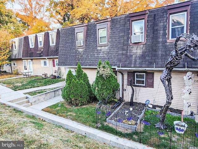 multi unit property featuring a front yard and cooling unit