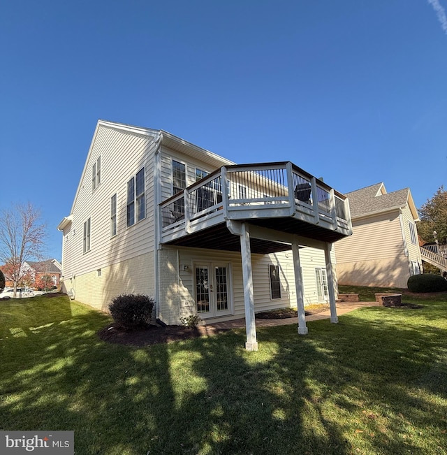 back of house featuring a wooden deck and a yard