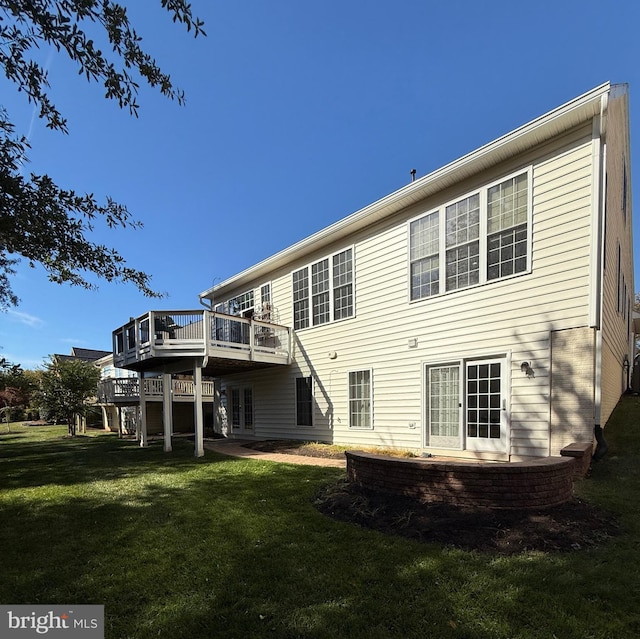 back of house featuring a wooden deck and a yard