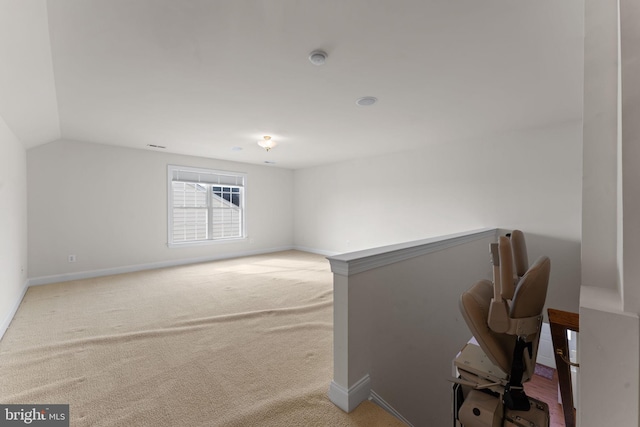 interior space with carpet flooring and vaulted ceiling