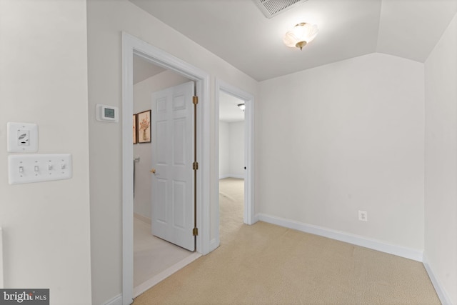 hallway with light colored carpet and lofted ceiling