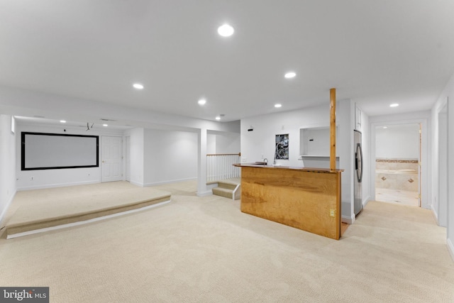 bar featuring white cabinets, light colored carpet, and stainless steel fridge