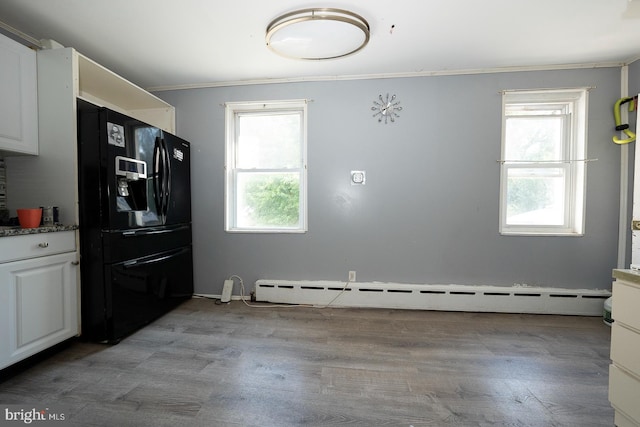 interior space featuring a baseboard heating unit and light wood-type flooring