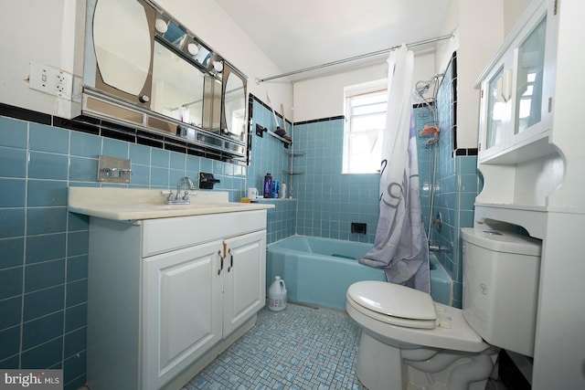 full bathroom featuring tile patterned floors, shower / bath combo, toilet, vanity, and tile walls