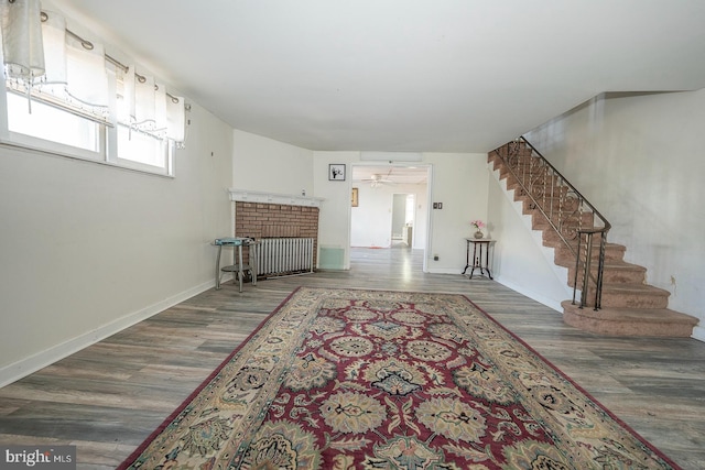 living room featuring dark wood-type flooring, a fireplace, and radiator