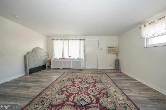 interior space featuring radiator, dark hardwood / wood-style flooring, and a wall mounted air conditioner