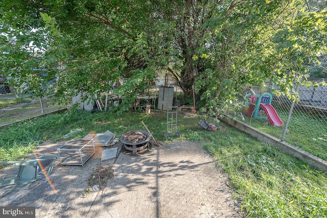 view of yard with an outdoor fire pit and a playground