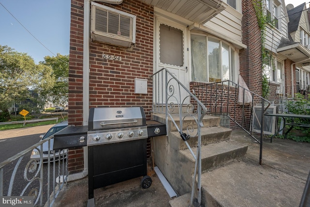 exterior space featuring cooling unit, a wall unit AC, and a grill