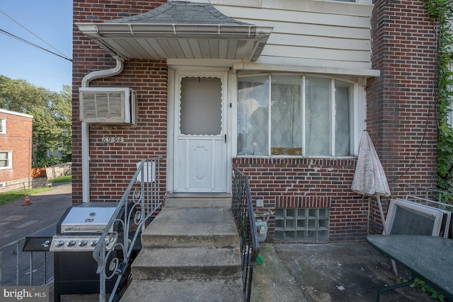 entrance to property featuring a patio and a wall mounted AC