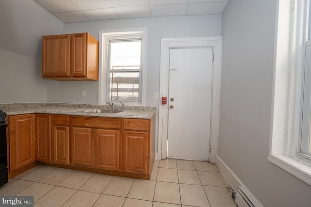 kitchen with light tile patterned flooring, sink, a drop ceiling, and a baseboard heating unit