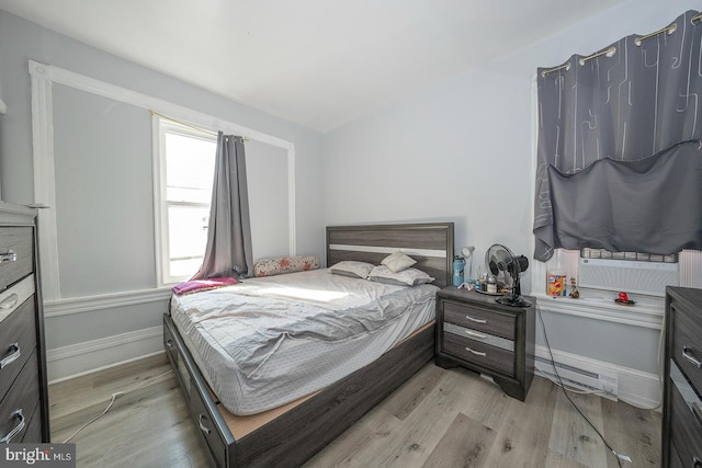 bedroom featuring light hardwood / wood-style floors and a baseboard radiator