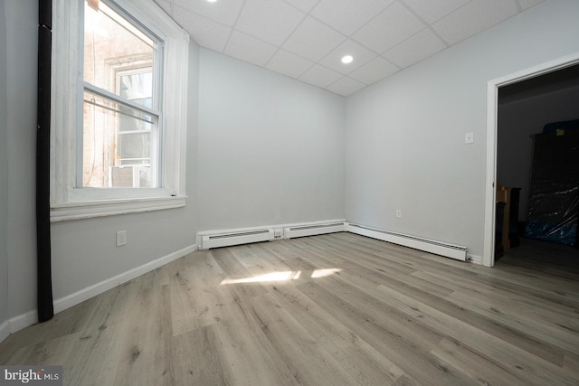 empty room with a paneled ceiling and light wood-type flooring