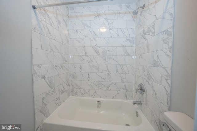 bathroom with toilet and tiled shower / bath combo