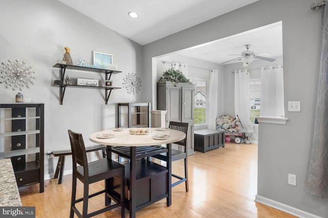 dining space with light hardwood / wood-style floors, vaulted ceiling, and ceiling fan