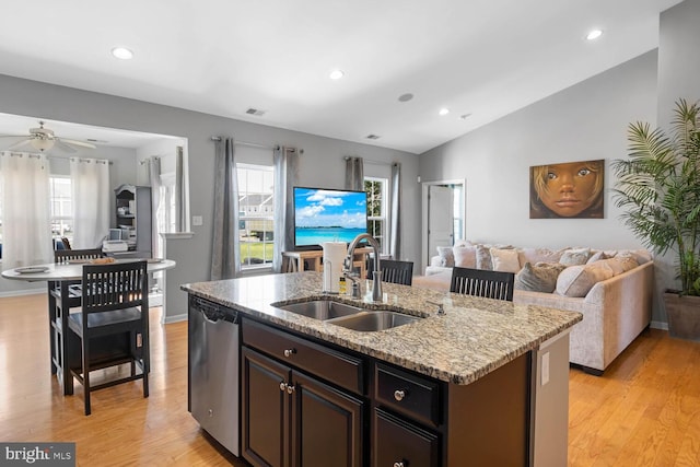 kitchen with lofted ceiling, dishwasher, sink, and an island with sink