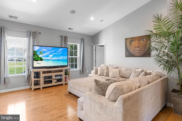 living room featuring lofted ceiling and light wood-type flooring