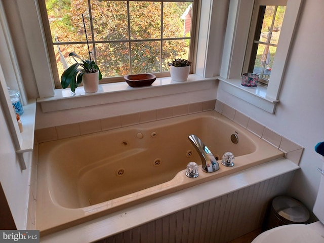 bathroom featuring a tub to relax in and toilet