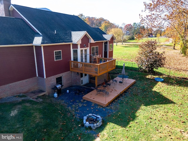 rear view of property with a yard and a deck