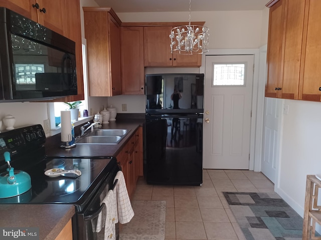 kitchen with light tile patterned floors, black appliances, plenty of natural light, a notable chandelier, and sink